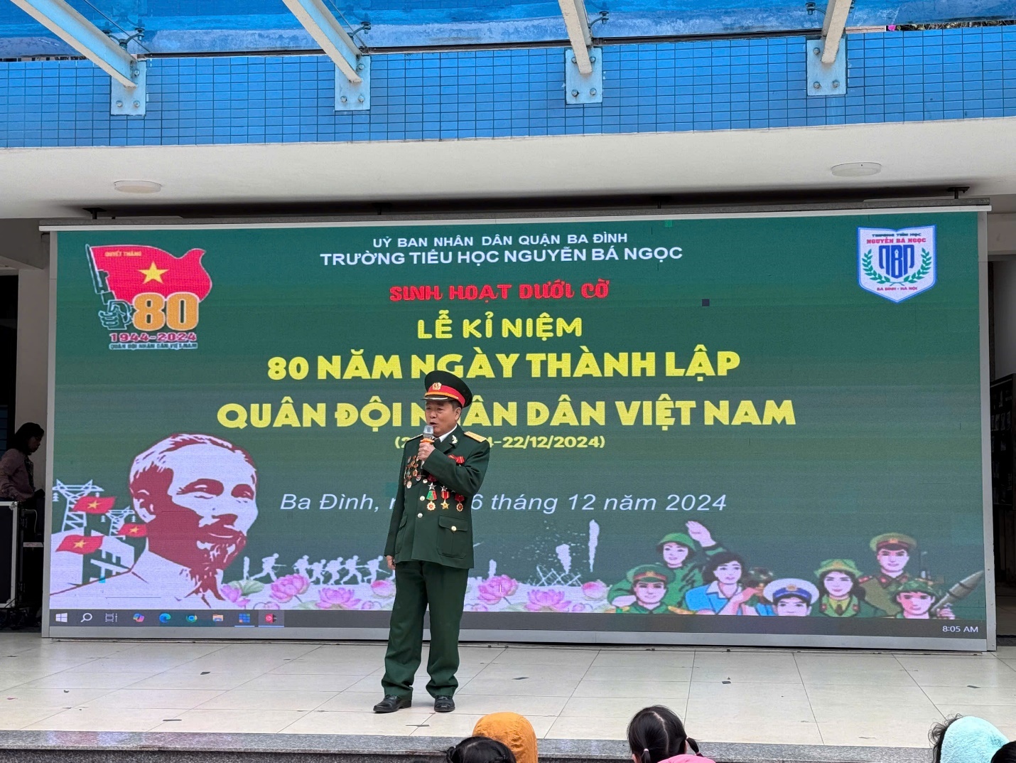 A person in uniform standing in front of a large sign

Description automatically generated