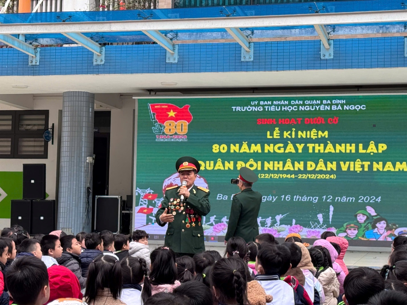 A person in uniform speaking to a group of people

Description automatically generated