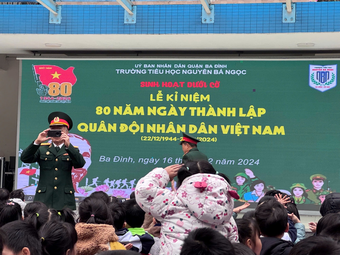 A person in uniform taking a picture of a crowd of people

Description automatically generated