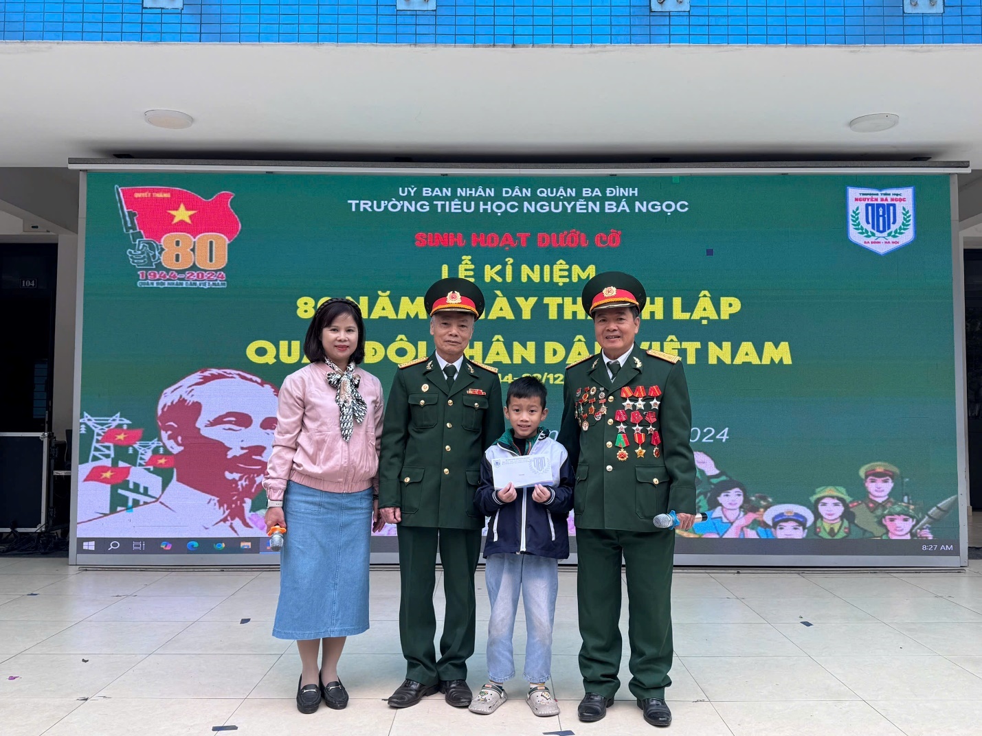 A group of people standing in front of a large sign

Description automatically generated
