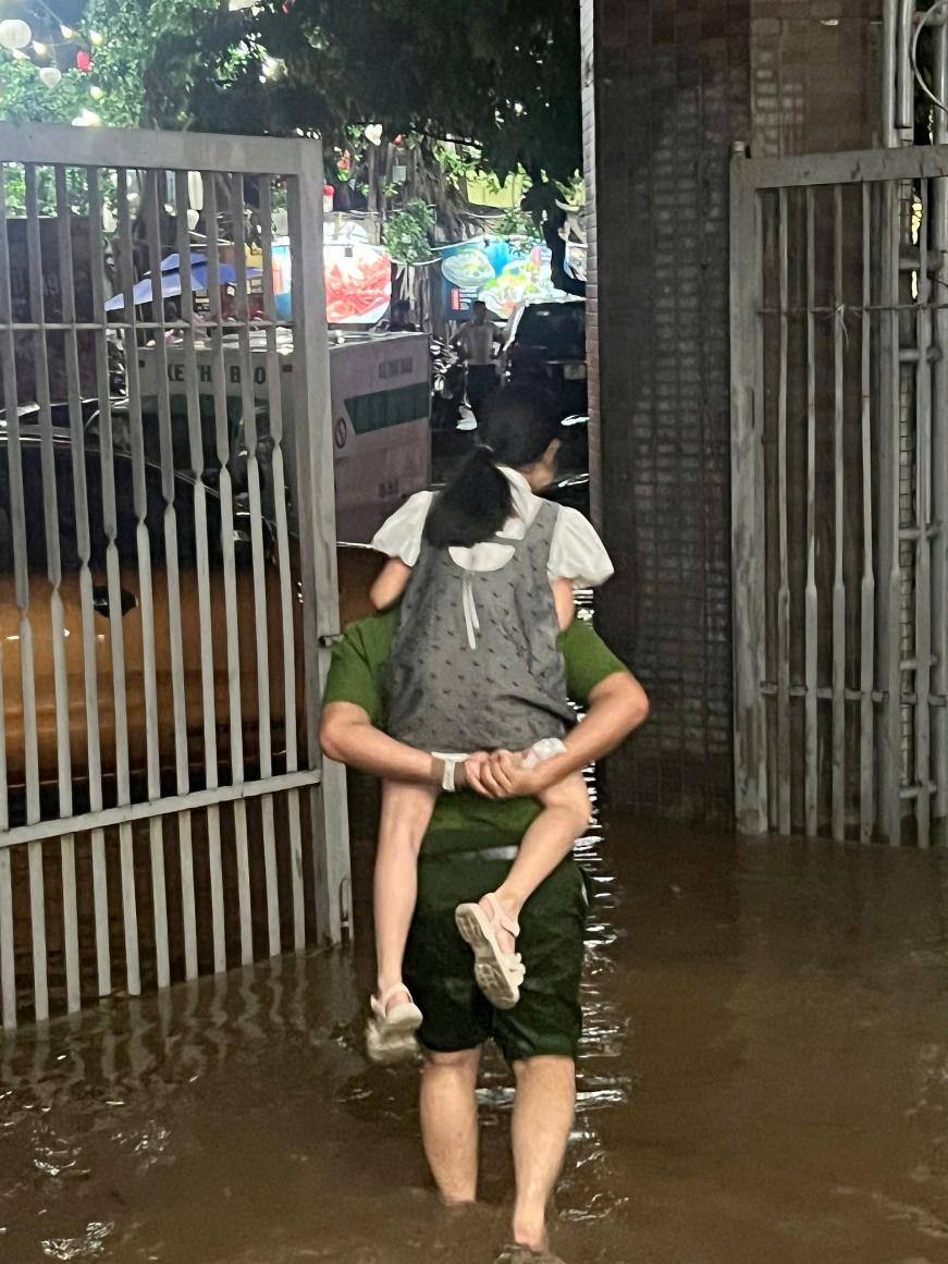 A person carrying a child on his back in a flooded area
AI-generated content may be incorrect.