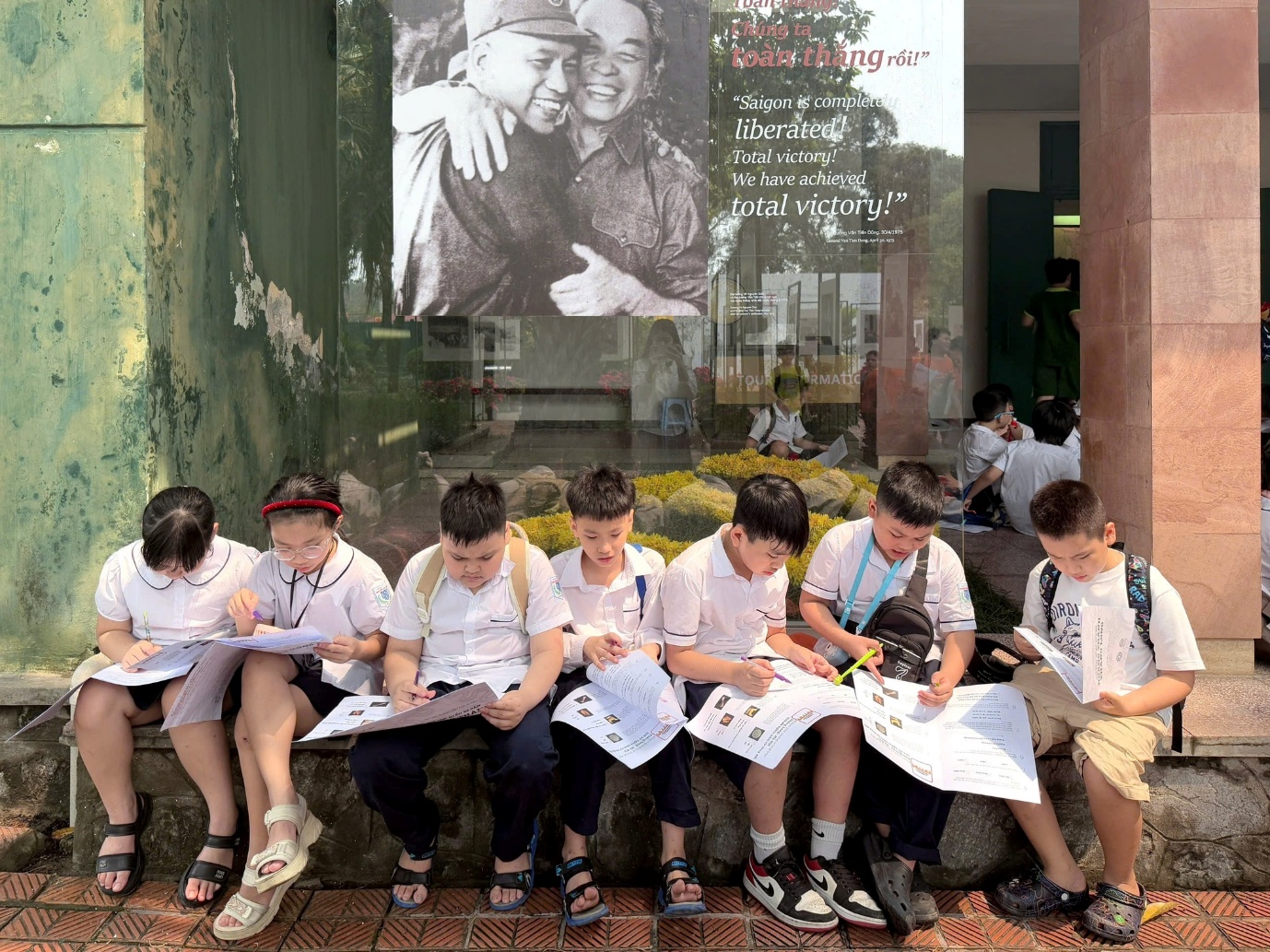 Có thể là hình ảnh về trẻ em, học tập và văn bản cho biết '!" angrồi!" rAA rồi!" hoakth "Saigon complece liberated! Total victory! We have achieved achieved ed total victory!" ဘ CA L ااماي ج 9 E 6lg0'